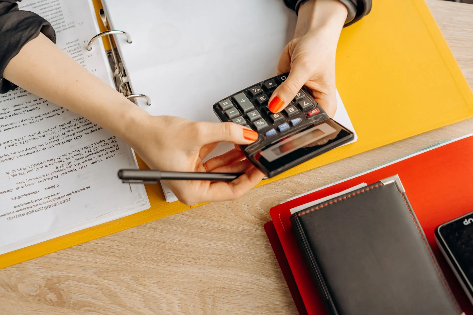Bookkeeper working through receipts and financial documents with a calculator